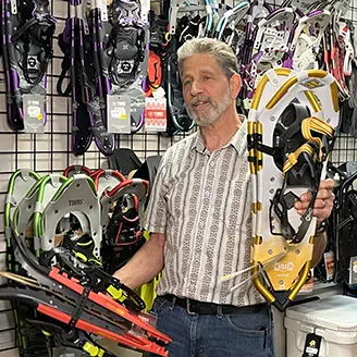 Man & Woman Holding a snowshoe in our camping department at Farm-Way inc / Vermont Gear