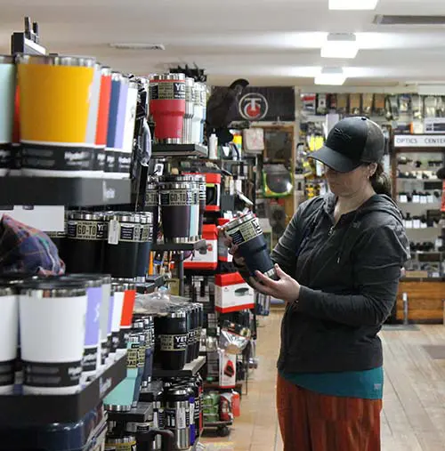 Man & Woman Holding a snowshoe in our camping department at Farm-Way inc / Vermont Gear